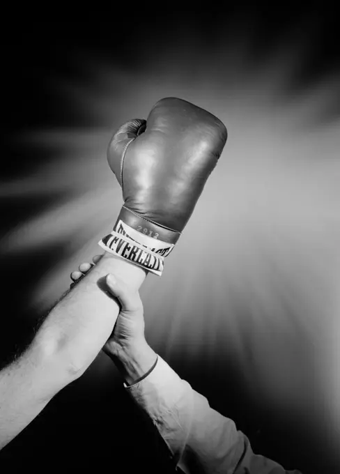 Hands of referee and winning boxer celebrating victory