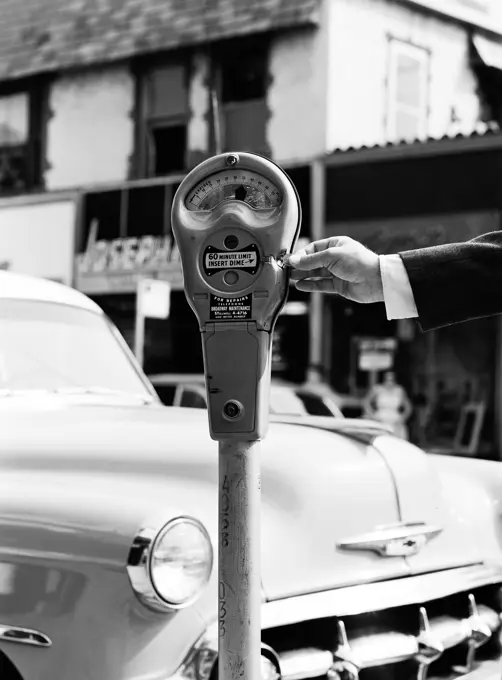 Man putting money into parking meter