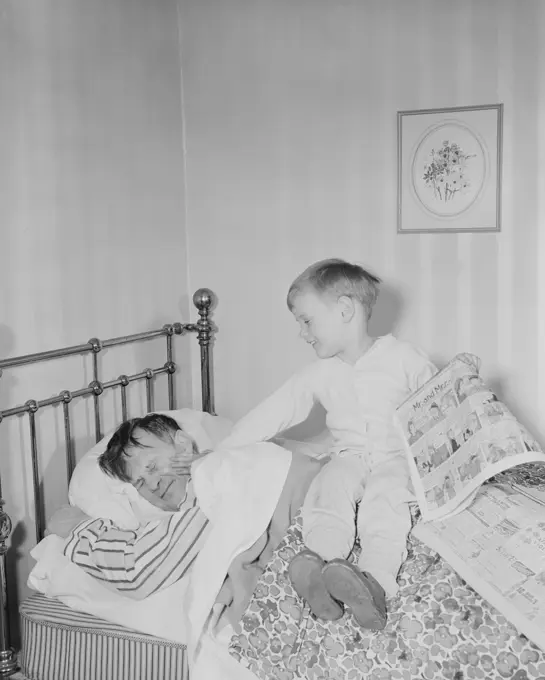 Boy waking father in bedroom