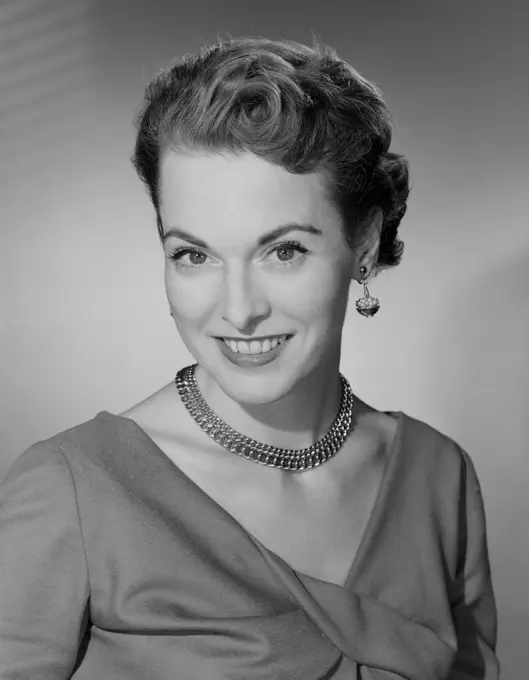 Studio portrait of mid adult woman smiling