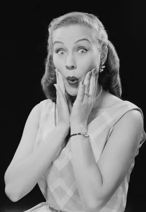 Studio portrait of young woman surprised.