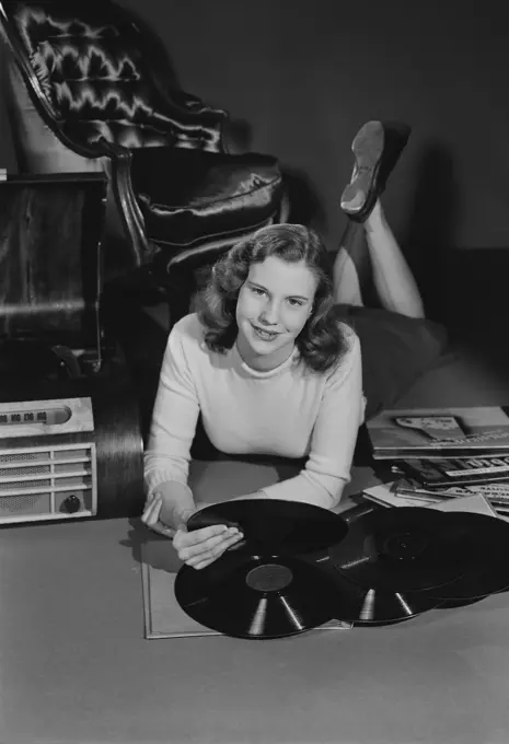 Studio portrait of young woman with records.