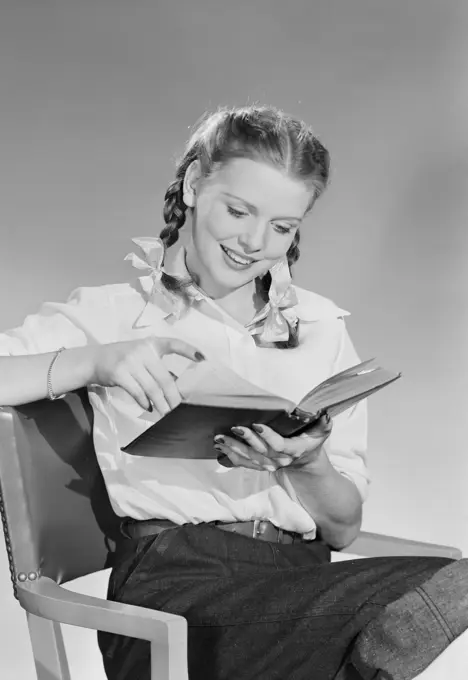 Teenage girl reading book.