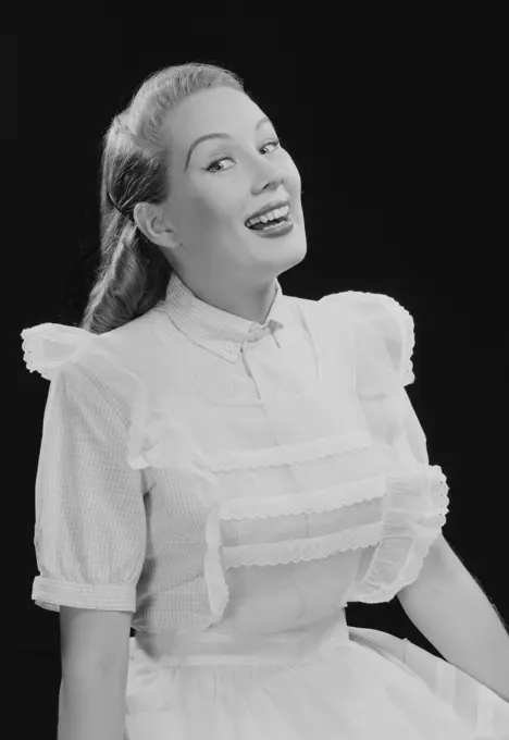 Studio portrait of young woman laughing.