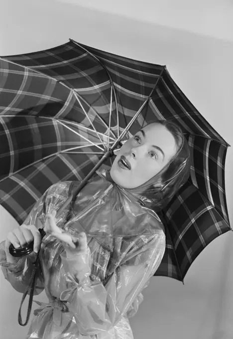 Studio portrait of young woman holding umbrella