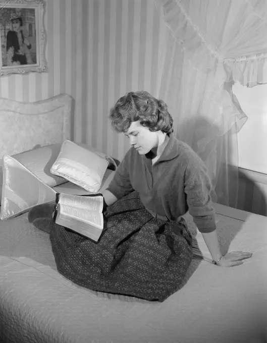 Girl reading book in bed