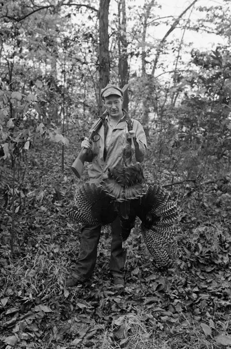 Hunter posing with dead peacock