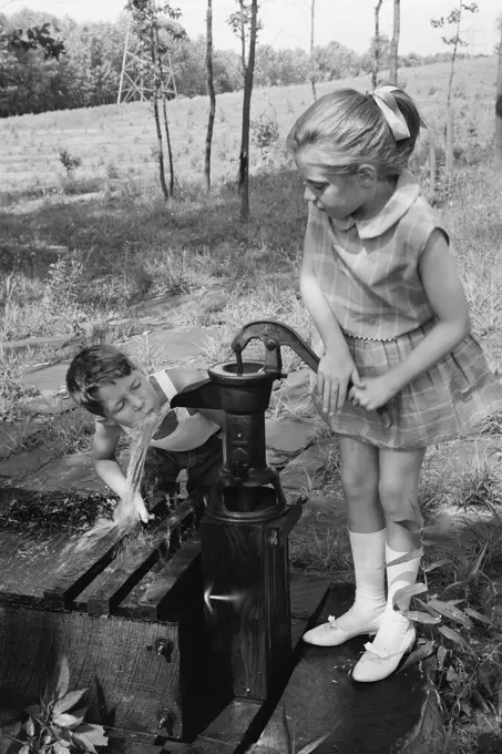 Boy drinking water as girl is drinking