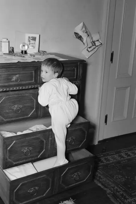 Girl playing on drawer chest