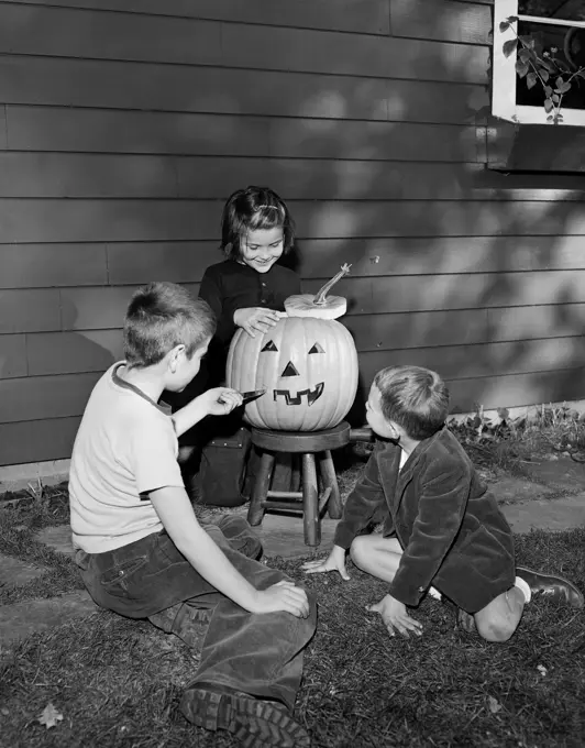 Boys and girl preparing pumpkin for Halloween party