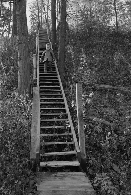 Boy walking on wooden steps outdoors