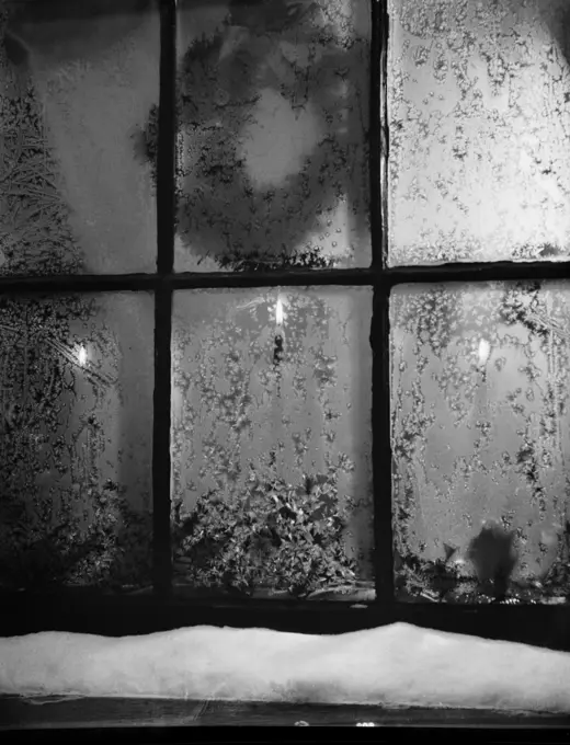 Frosted window with Christmas decoration behind