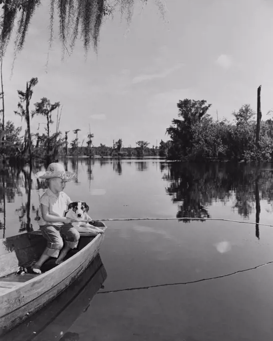 Boy fishing with dog by side