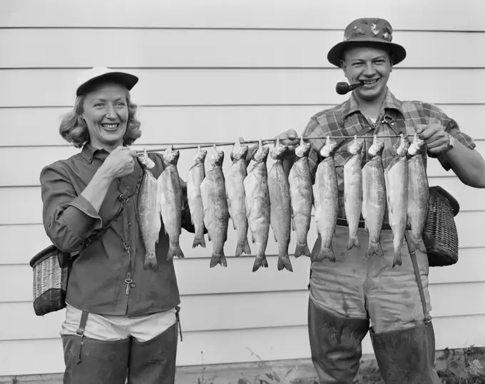 USA, Cascade Mountain Lake, woman and man holding Rainbow Trout