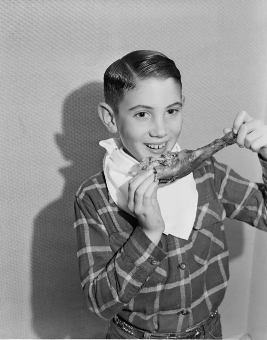 Boy eating turkey leg