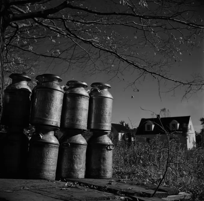 Milk cans on rural road side waiting to be picked up