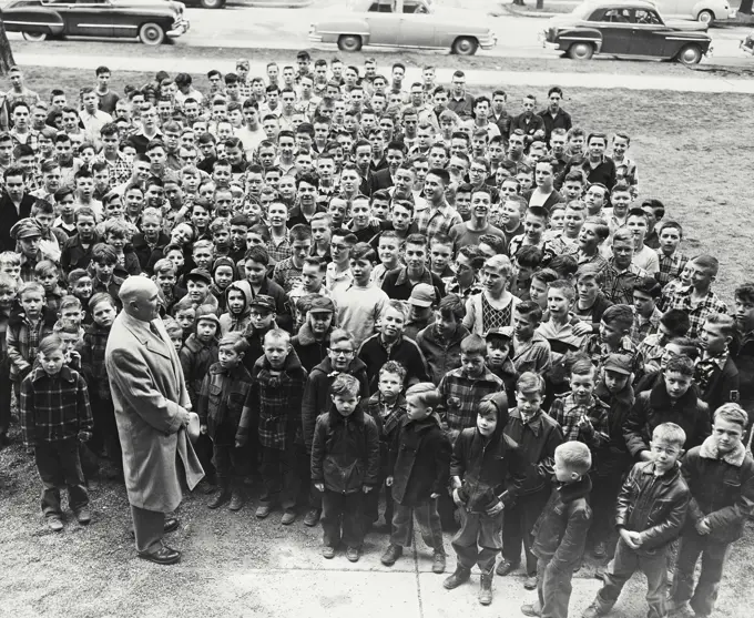 Vintage photograph. High angle view of a school principal giving a speech to his students