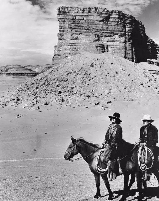 Two Navajo men riding horses