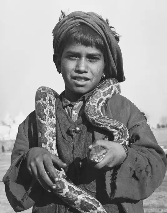 Boy holding a snake around his neck