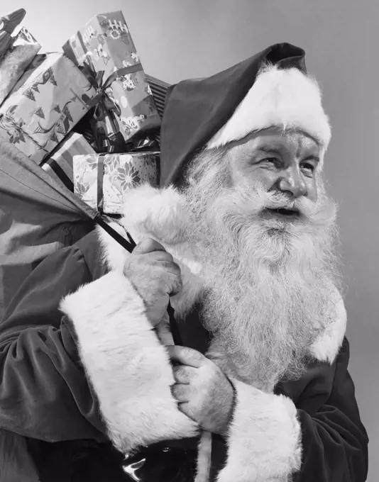 Close-up of Santa Claus carrying a sack of Christmas presents on his back