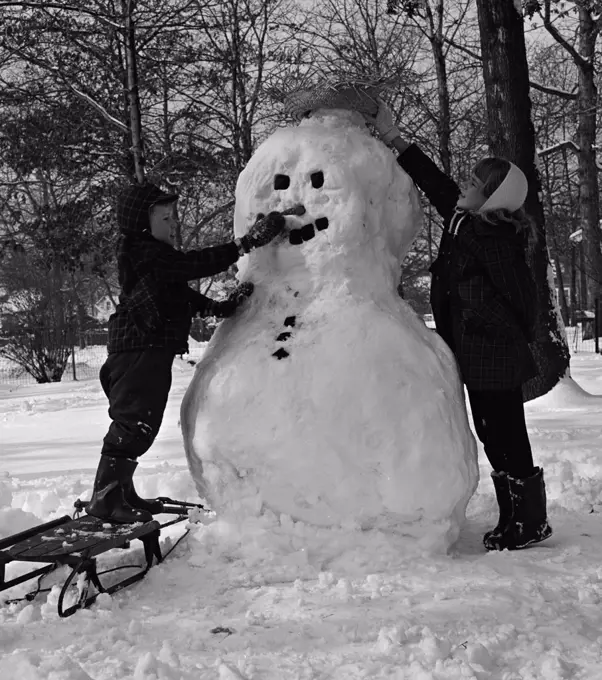 Two boys making snowman