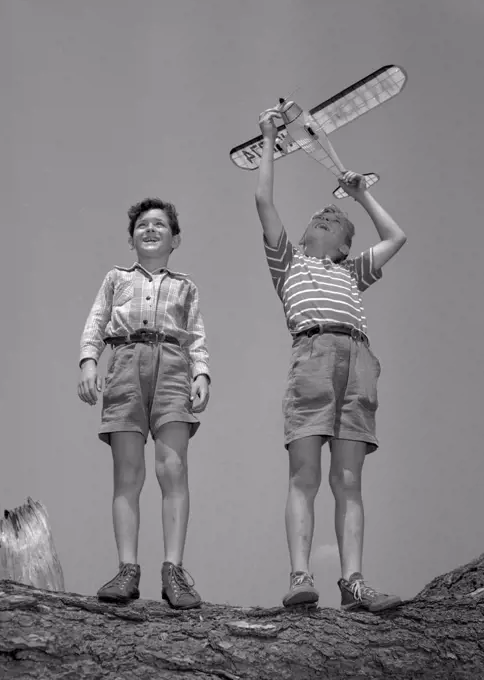 Boys playing with model airplane