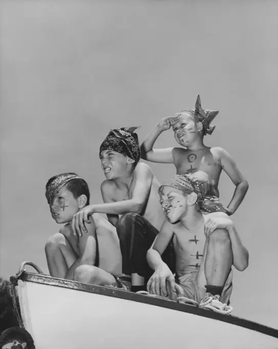 Four boys sitting on a boat and pretending to be pirates