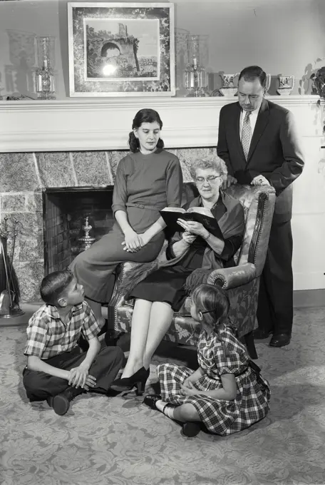 Vintage Photograph. Multi-generational family portrait with the elder reading the bible to other family members.