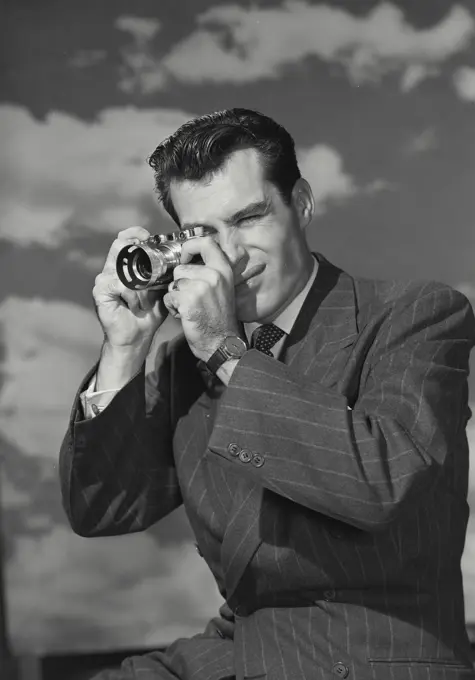 Vintage photograph. Close-up of a mid adult man taking a photograph