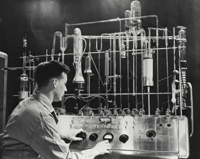 Vintage photograph. Engineer using Vacuum Fusion Gas Analyzer to determine the exact amount of oxygen, hydrogen, and nitrogen in various metals and alloys to aid for clues to better jet engines