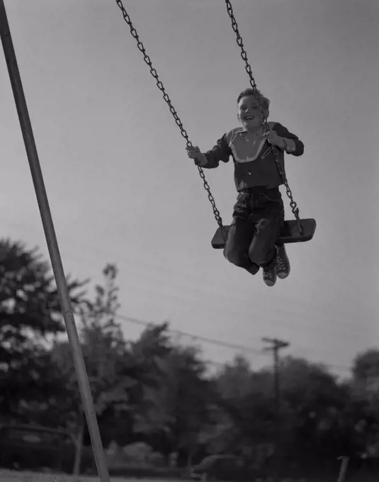 Low angle view of a boy on a swing