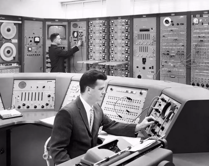 Side profile of two technicians working in a computer lab