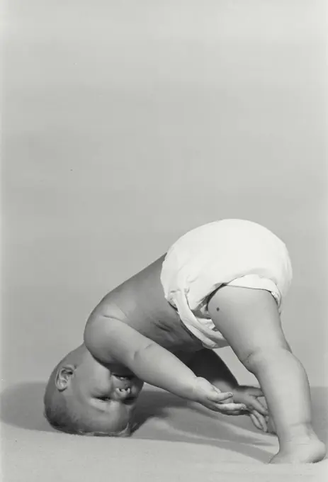 Vintage Photograph. Baby comically leaning upside down on its head