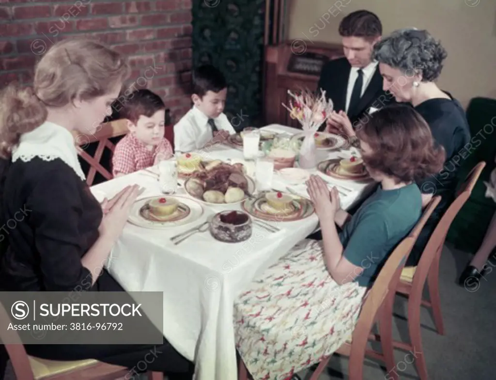 Family praying at the dining table