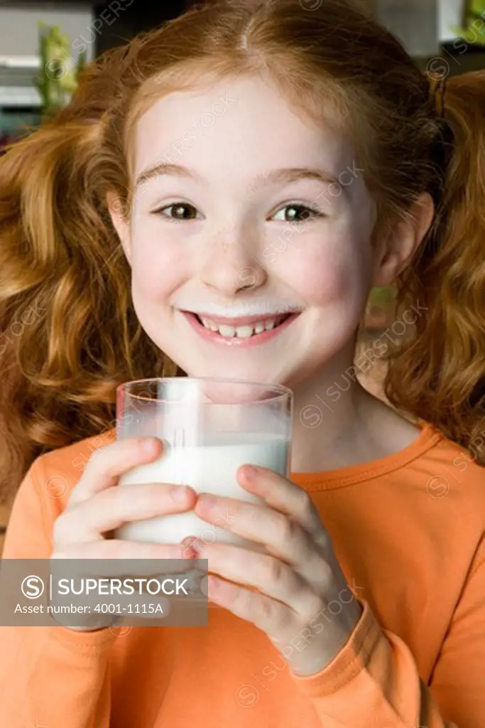 Girl drinking glass of milk with milk mustache