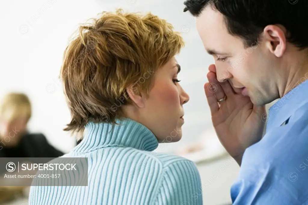 Office workers whispering in an office