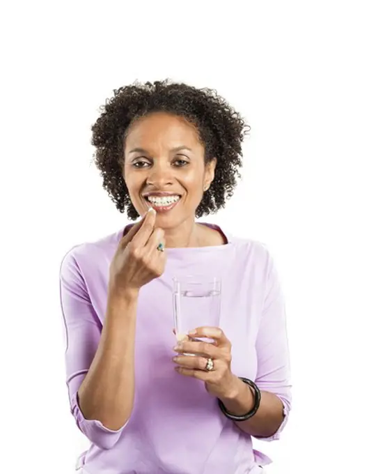 Portrait of a mid adult woman taking medicine