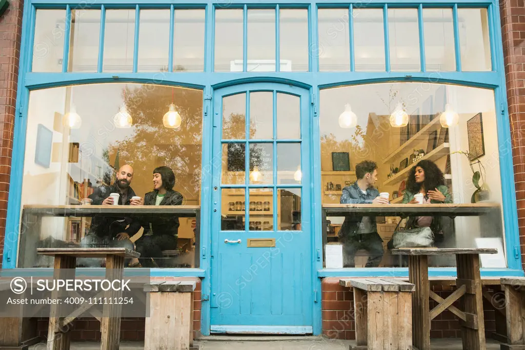 Friends sitting in window of cafe