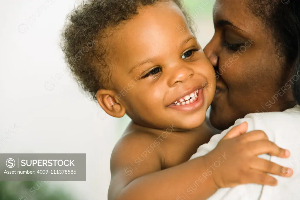 African mother kissing baby