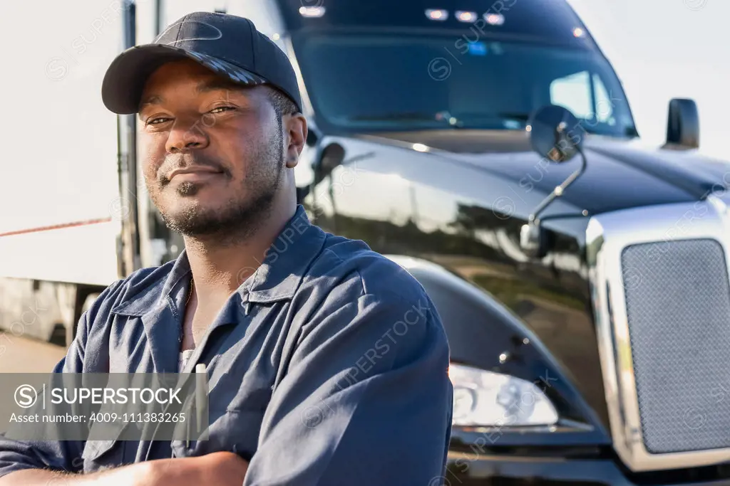 Smiling man standing near semi-truck