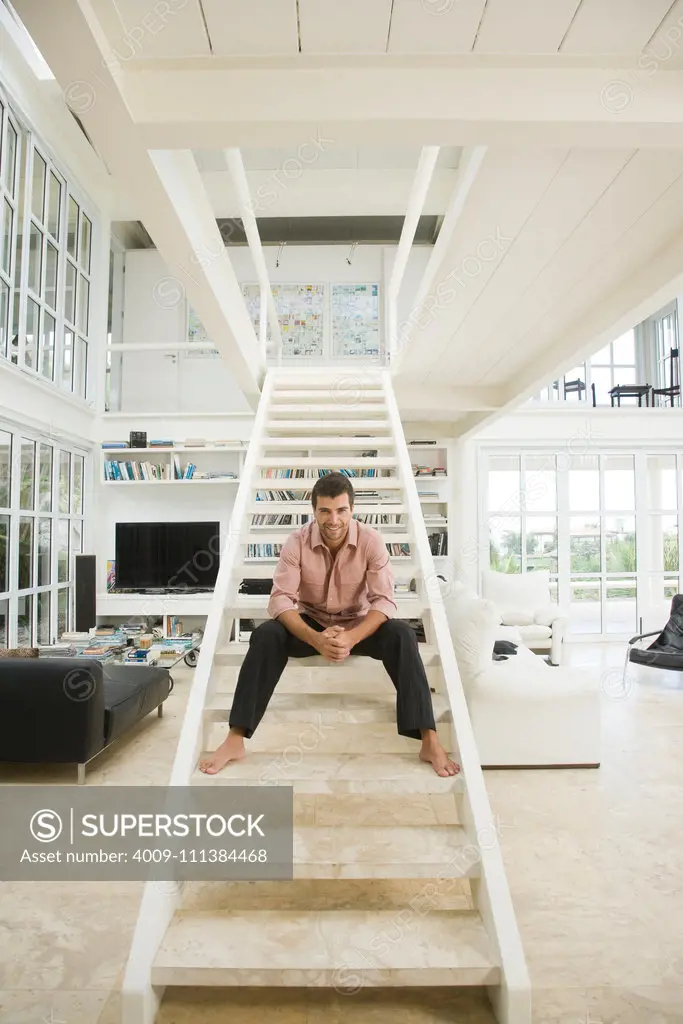 Hispanic man smiling on staircase