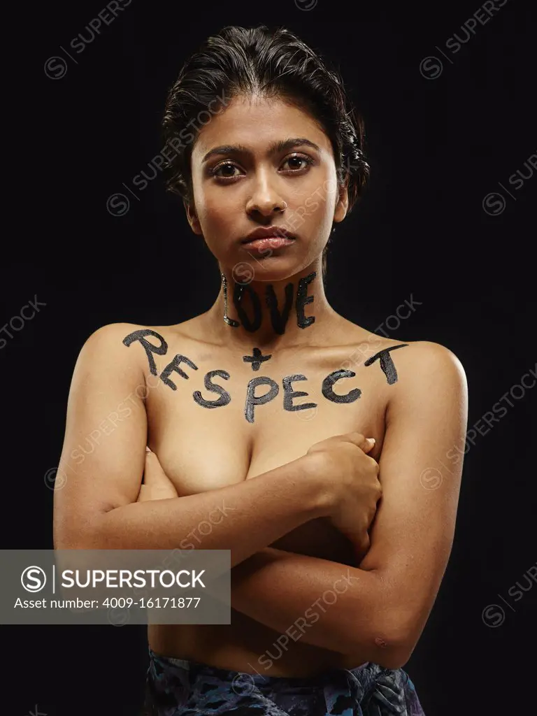 Portrait of Indian woman with arms crossed and words painted