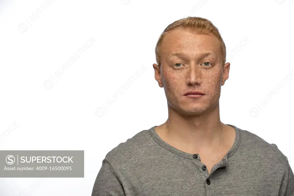 Portrait of young man looking off camera with straight face 