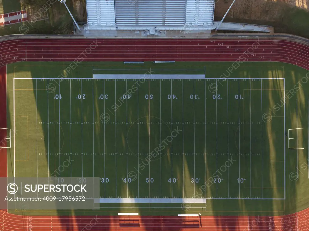 Aerial straight down shot of a high school track and football field in Texas at sunrise