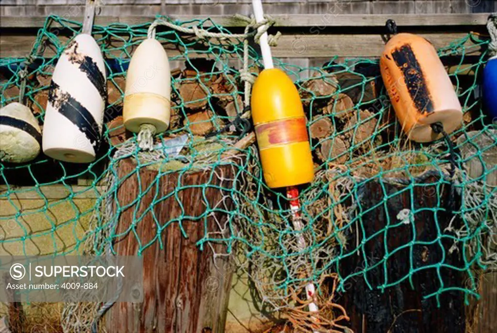 Buoys and a fishing net hanging to the edge of a dock at Menemsha