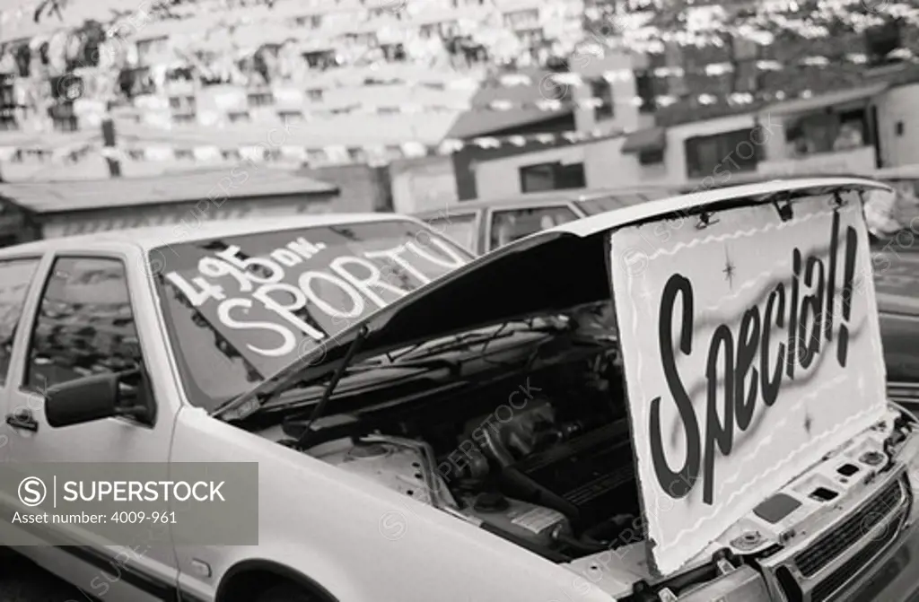 Hood of car open to display Special! at car dealership