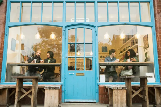 Friends sitting in window of cafe