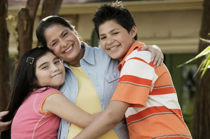 Hispanic grandmother hugging grandchildren