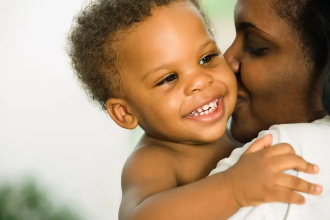 African mother kissing baby