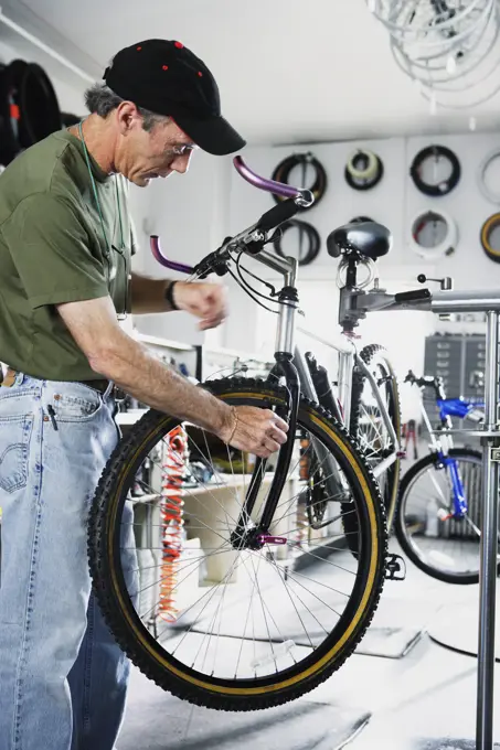 Man repairing bike in bike shop